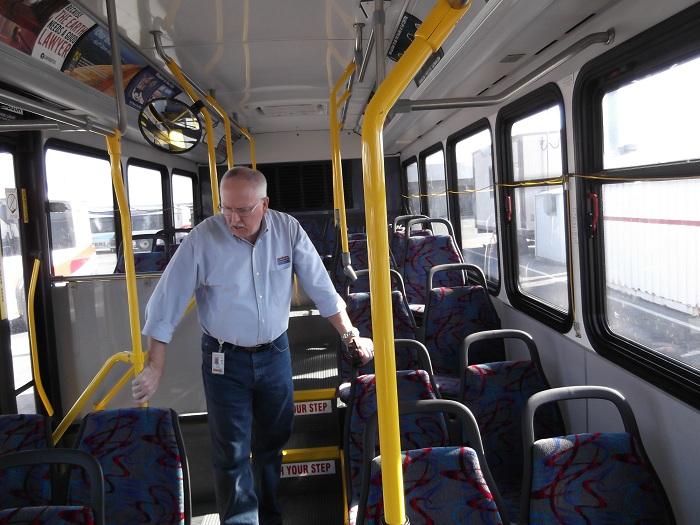 SamTrans deputy CEO, Chuck Harvey examines a bus during base inspection.