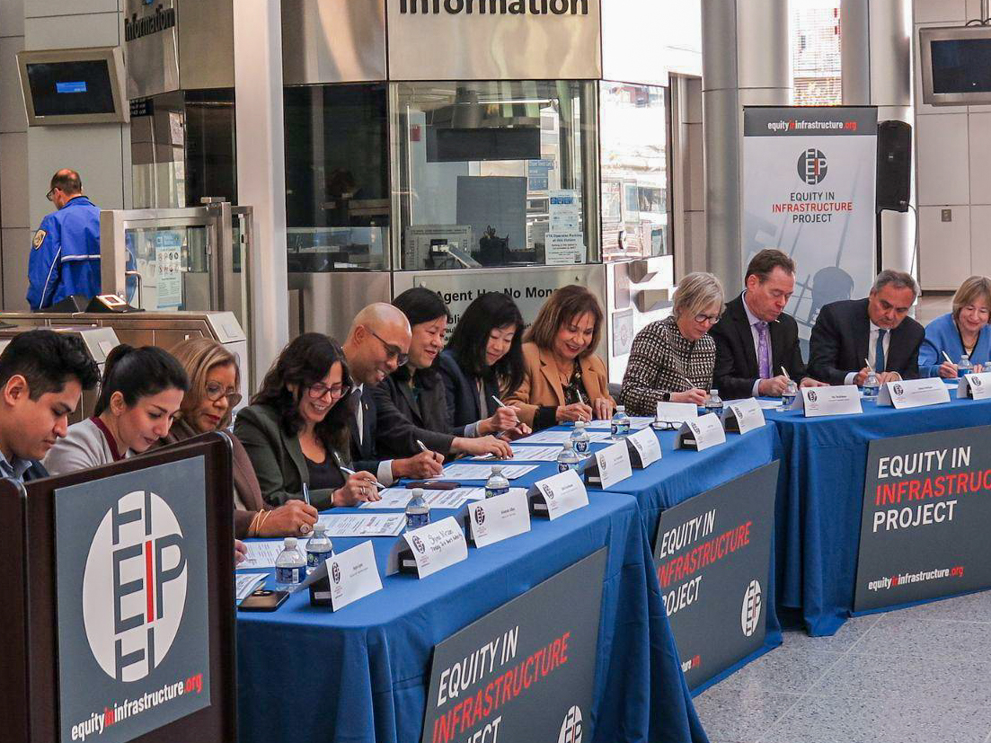 People sitting behind tables at Equity in Infrastructure Project event