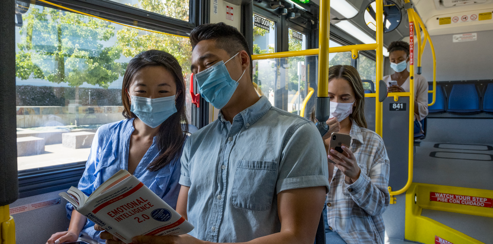 Students Reading Book on Bus