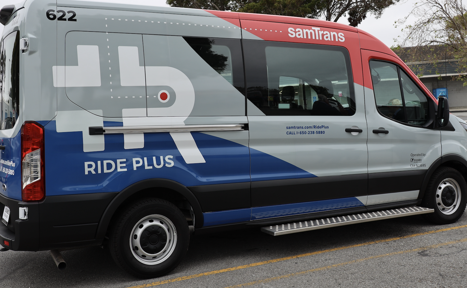 A Ride Plus van parked in a parking lot in Half Moon Bay.