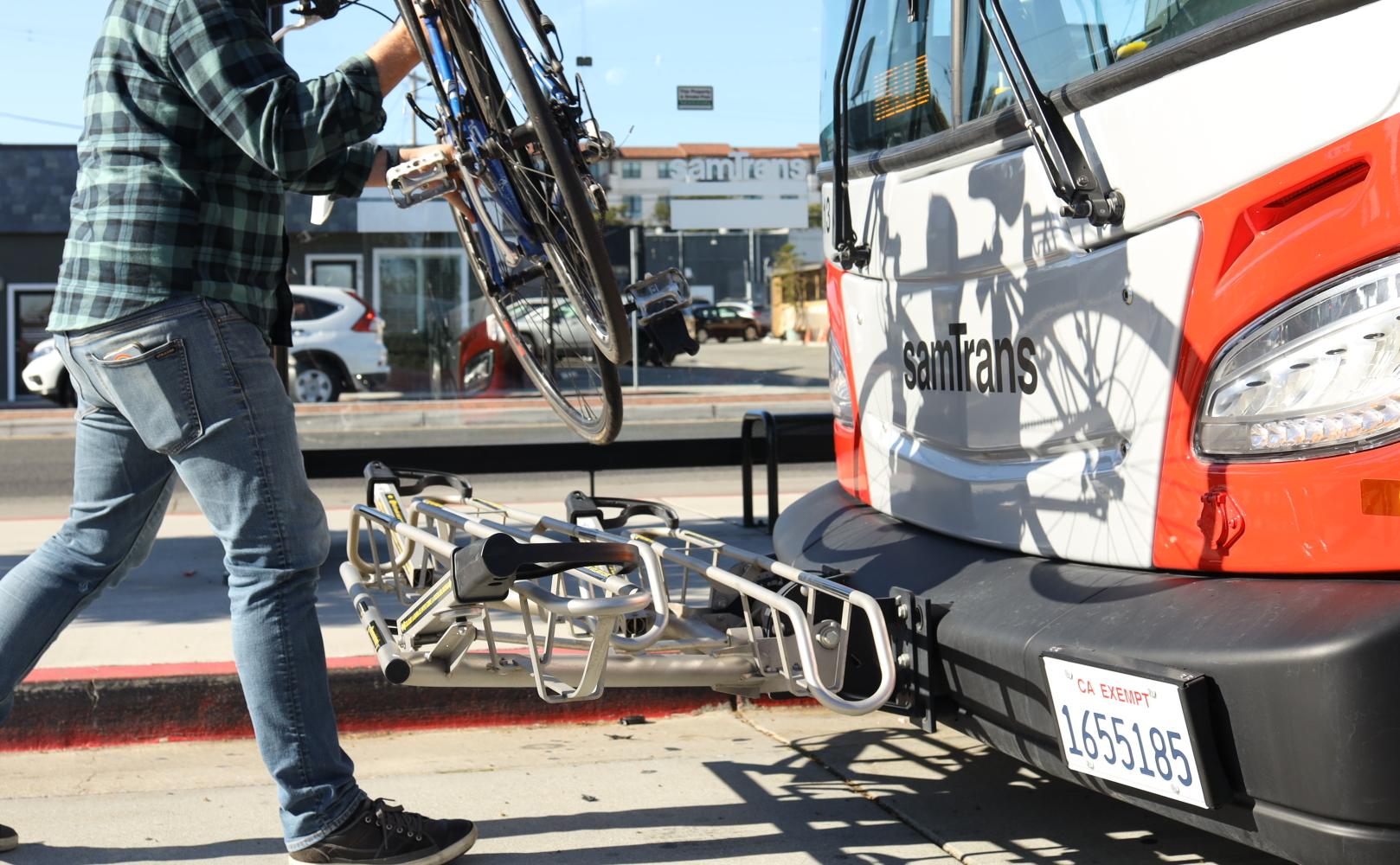 Cyclist places bicycle on SamTrans bus bike rack
