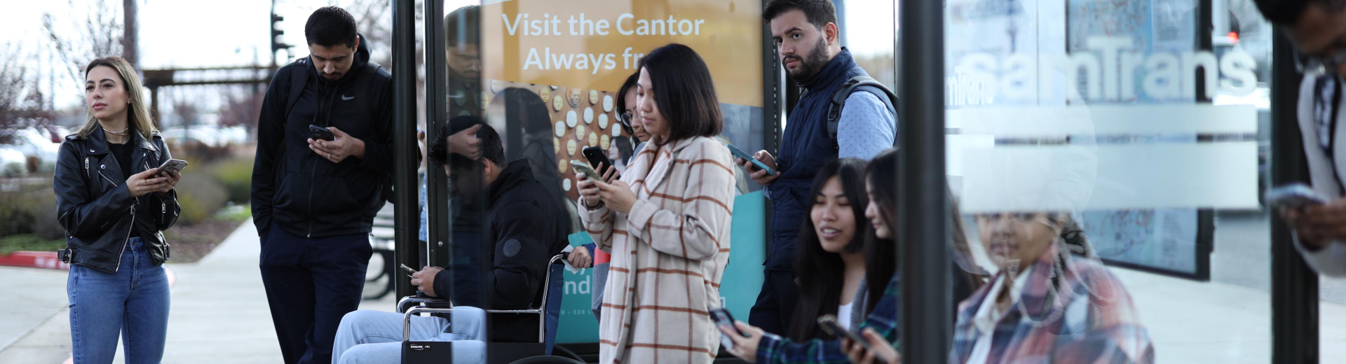 Crowd waits for bus at SamTrans bus stop