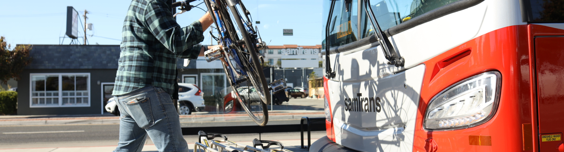 Cyclist places bicycle on SamTrans bus bike rack