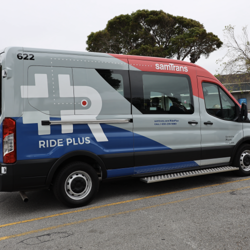 A Ride Plus van parked in a parking lot in Half Moon Bay.
