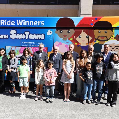 Winners in front of wrapped bus