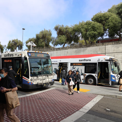 People crossing street near SamTrans buses