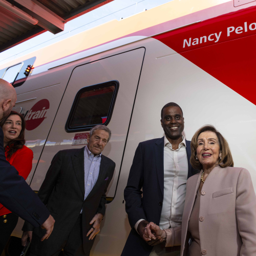 Nancy Pelosi posing in front of train named in her honor